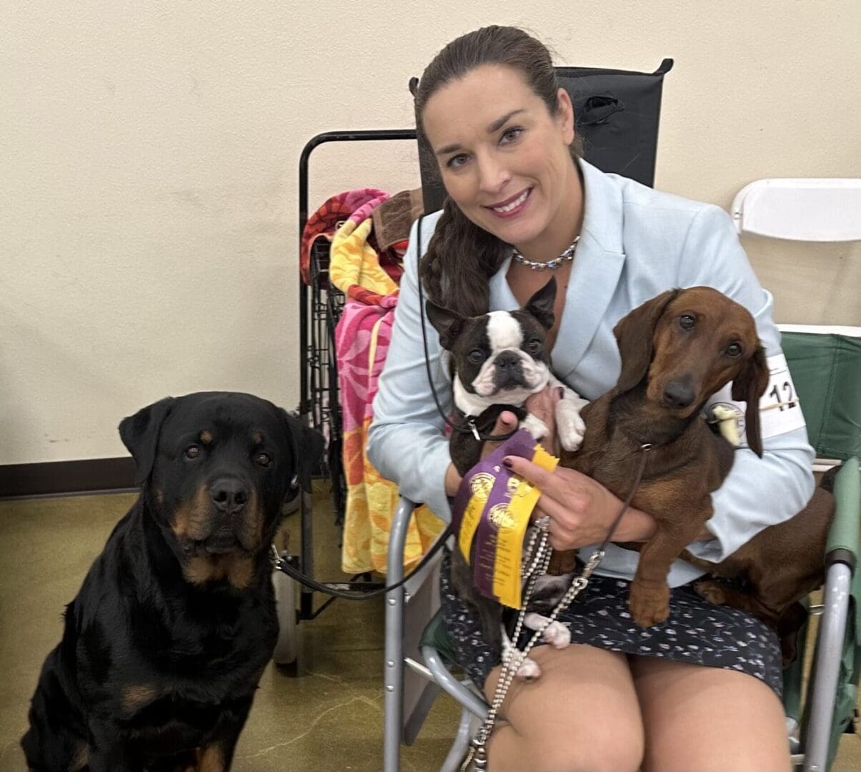 A woman holding two dogs in her lap.