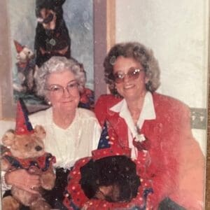 Two women with dogs in costumes.