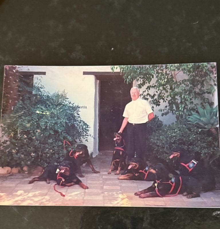 Man with five Doberman Pinschers.