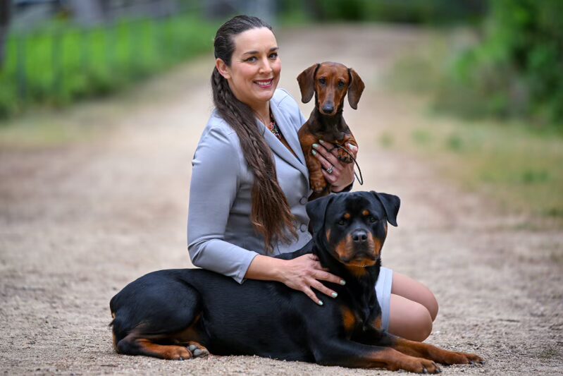 Woman with two dogs on a path.